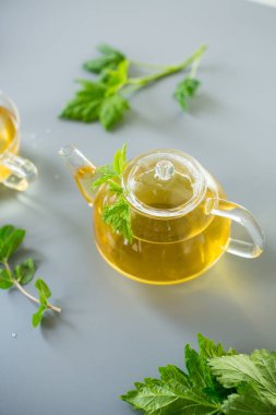 Doğal yeşil çay, gri arka planda cam bitkiler..