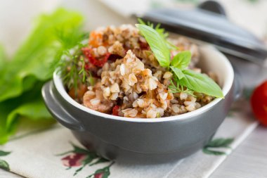 Tahta bir masada seramik kasede sebzeli haşlanmış karabuğday..