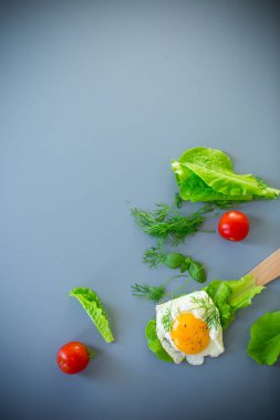 Mutfakta salata yapraklı, gri arka planda lezzetli yumurta yakın plan..