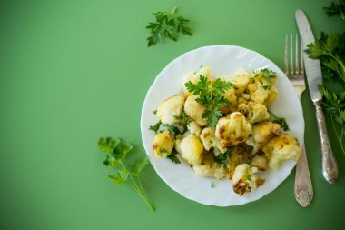 Yeşil arka planda maydanozlu gevrek karnabahar manzarası.