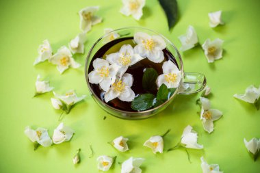 Yasemin ve yeşil çay şeffaf bir çaydanlıkta yakın planda..