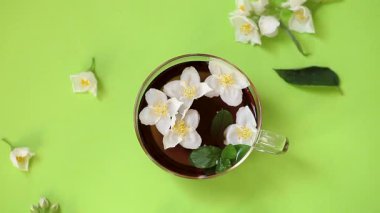 Yukarıdan cam çaydanlıkta yaseminli yeşil çay.