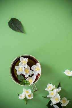 Yukarıdan cam çaydanlıkta yaseminli yeşil çay.