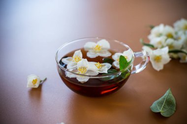 Kahverengi arka planda yasemin yapraklı doğal yeşil çay..