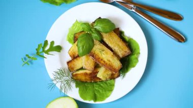 Kızarmış kabak dilimleri ve salata yeşili..