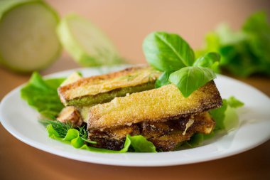 Kızarmış kabak dilimleri ve salata yeşili..