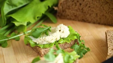 Roka, salata ve yumuşak peynirli sağlıklı bir sandviç..