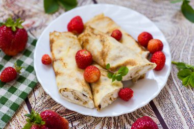 İştah açıcı krepler ve ahşap bir masada izole edilmiş böğürtlenler.