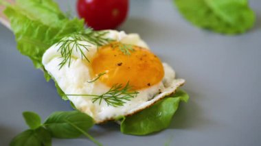 Gri arka planda ahşap spatulada yeşil yumurta..