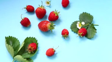 Mavi arkaplanı olan kırmızı çileklerin üst görüntüsü.