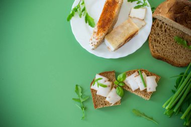 Yeşil zemin üzerinde domuz yağı ve yeşillik bulunan geleneksel Ukrayna yemeği.