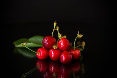 Siyah arka planda tatlı kırmızı kiraz hasadı.
