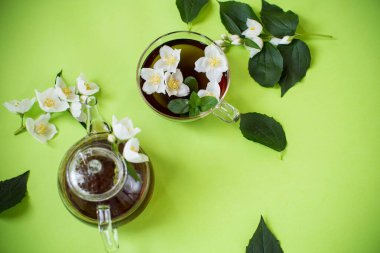 Yukarıdan cam çaydanlıkta yaseminli yeşil çay.