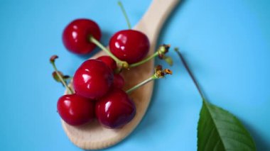 Yukarıdan mavi arkaplanda olgun kırmızı kirazlar.