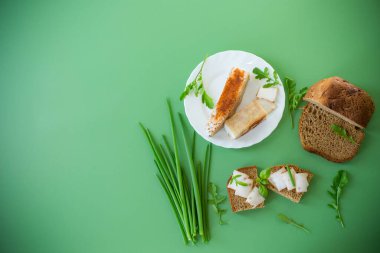 Çavdar ekmeğine domuz yağlı sandviç ve üstüne yeşil soğan..