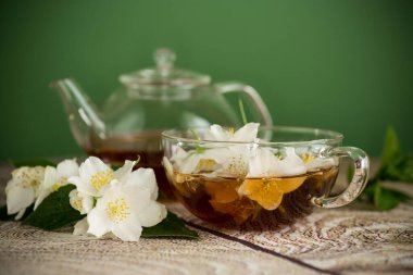 Yasemin çiçekleri ve yeşil bir fincanda çay..