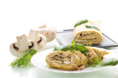 Beyaz arka planda mantarlı ev yapımı kabak rulosu..