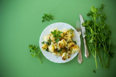 Yeşil arka planda maydanozlu gevrek karnabahar manzarası.