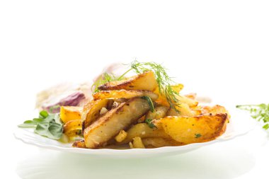 Beyaz arka planda kıtır kıtır ve baharatlı altın patatesler.