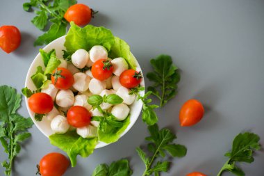 Mozzarella, kiraz domatesleri ve yeşilliklerle nefis bir kompozisyon..