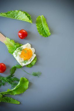 Mutfakta salata yapraklı, gri arka planda lezzetli yumurta yakın plan..