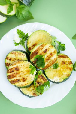 Yeşil arka planda kızarmış kabak dilimleri..