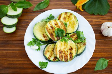 Koyu ahşap arka planda ızgara kabak dilimleri..