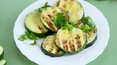 Yeşil arka planda kızarmış kabak dilimleri..