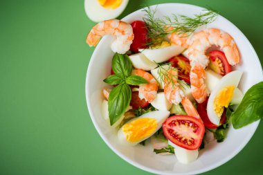 Sebze salatası ve yeşil arka planda öğle yemeği için deniz ürünleri ve peynir..