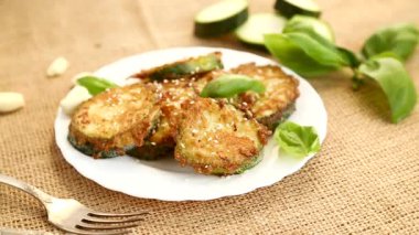 Bol yağda kızartılmış kabak parçaları, susam ve taze fesleğen..