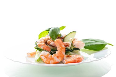 Beyaz arka planda karides ve salatalıklı taze sebze salatası..