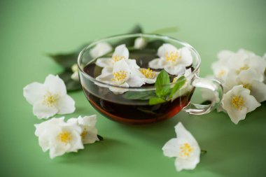 Yukarıdan cam çaydanlıkta yaseminli yeşil çay.