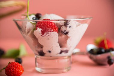 Doğal böğürtlenli ev yapımı dondurma ile pembe arka plan.