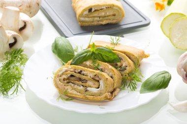 Beyaz arka planda izole edilmiş peynir ve mantarlı kabak rulosu..