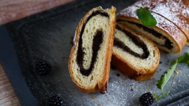 Haşhaş tohumları ve böğürtlenlerle dilimlenmiş tatlı rulo.