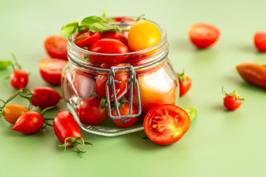 Cam kavanozda fesleğen yapraklı kiraz domatesleri..