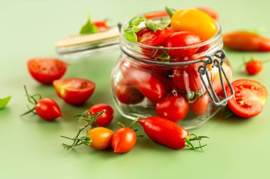 Kavanozdan dökülen taze kırmızı ve sarı domatesler..