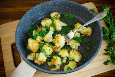 Kızarmış karnabahar, tavada baharat ve otlar..