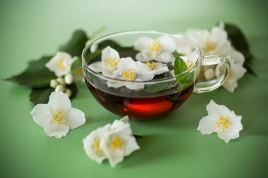 Yukarıdan cam çaydanlıkta yaseminli yeşil çay.