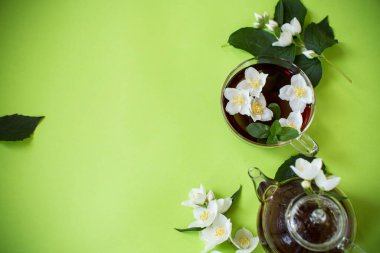 Yukarıdan cam çaydanlıkta yaseminli yeşil çay.