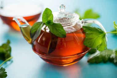 Mavi arka planda naneli ve üzümlü aromalı bitki çayı..