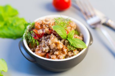 Gri arka planda sebzeli karabuğday. Basit bir yemek..