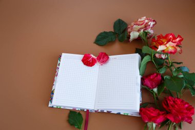 Taze gül yaprakları arasında bir fincan kapuçino üzerine notlar..