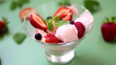 Yeşil arka planda böğürtlenli kremalı dondurma.