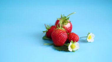 Mavi arkaplanı olan kırmızı çileklerin üst görüntüsü.