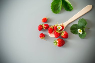 Gri bir yüzeyde olgun çilekler..