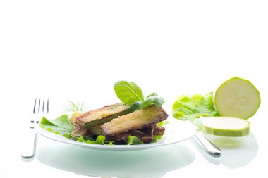 Kızarmış kabak dilimleri ve salata yeşili..