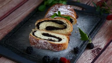 Haşhaş tohumları ve böğürtlenlerle dilimlenmiş tatlı rulo.