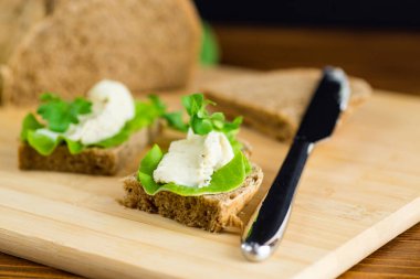 Roka, salata ve yumuşak peynirli sağlıklı bir sandviç..