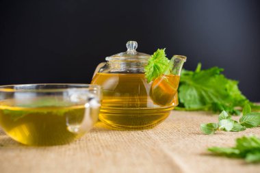 Siyah arka planda naneli ve üzümlü aromalı bitki çayı..